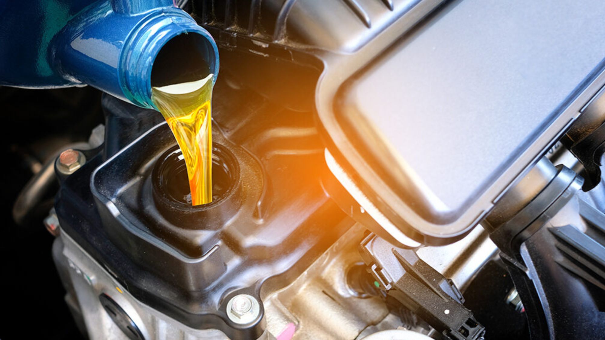 A man putting motor oil in his car engine to maintain vehicle hydration and avoid car breakdowns